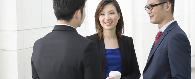 Three formally dressed individuals discussing in a circle